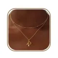 Gedetailleerd overzicht van de elegante dubbele gouden letter R ketting in minimalistische stijl. - Letter R