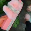 Gros plan de sandales plates roses en fausse fourrure et strass brillants montrant les details. - Rose