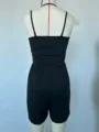 Detail view of the back of a black casual sleeveless romper showing straps and slim fit. - XS / Back View