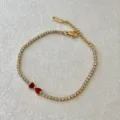 Stiloso bracciale tennis dorato con zirconi brillanti e ciondoli di cuore rossi. - Fiocco Rosso Tinta Unita