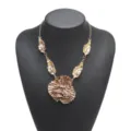 Detailed view of statement metallic gold ruffled flower pendant necklace with leaf charms. - 3D Floral Necklace (N14269) / Dark Brown