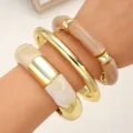 Elegant stacked bracelet set featuring smooth gold metal and chic resin segments for women. - Bamboo Ring Resin Bangle Set (6764602HB)