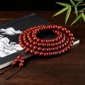 Gros plan détaillé de bracelet de perles en bois rouge traditionnel sur fond de table sombre. - Matériau Vieilli Premium Haute Densité / 6mm*108 Perles