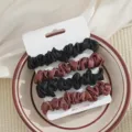 Detailopname van satijnen haarrekkers set in zwart en bruin kleuren op keramische schaal. - Zwart en Koffie