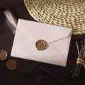Enveloppe texturée rose avec sceau de cire doré, élégant détail de papeterie vintage. - Rose