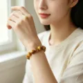 Gros plan détaillé du magnifique bracelet de perles en cristal naturel au poignet. - Bracelet Oeil de Tigre Doré 8mm