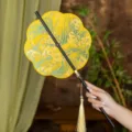Chinese style round fan, yellow brocade silk pattern with tassel and black bamboo handle variant. - 8-Petal Tulip Waist Fan (Bamboo Edge)