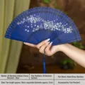 Blue hollow bamboo folding fan with delicate cherry blossom patterns, traditional Chinese style. - Blue Cherry Blossom