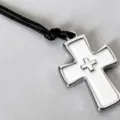 Detail shot of a vintage punk white enamel cross pendant necklace with black cord. - White Cross Necklace
