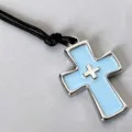 Detailed shot of light blue enamel cross pendant necklace with black cord. Chic accessory. - Blue Cross Necklace