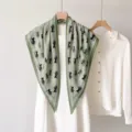 Vue détaillée de l'élégant foulard en soie vert à motif de calèche avec robe blanche. - 135x80cm / RY-30