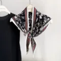 Vue détaillée d'un élégant foulard triangulaire en soie noire à motif floral et rayures. - 135x80cm / RY-34