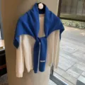 Elegante bufala de punto azul drapeada sobre un suéter blanco clásico, ideal para otoño e invierno. - Chal Plano de Lana / Azul Real