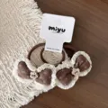 Detalle de dos coleteros marrones de tela con lazo, borde de encaje blanco y flores metálicas - Goma de Pelo con Lazo