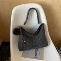 Donkergrijze gestreepte schoudertas met bruine imitatieleren rand en zachte pompon als decoratie - Stijl Met Hanger / Zwart