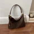 Bruin gestreepte schoudertas met wollook, leren handvat, goudkleurige details en decoratieve pompon - Stijl Met Hanger / Mocha Bruin
