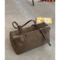 Bolso marrón de ante sintético, forma cilíndrica, con asas oscuras, herrajes plateados y cremallera - Sin colgante / Verde