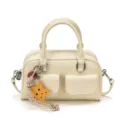 Front view highlighting two stitched pockets, twin handles, silver hardware and a yellow star charm. - With Pendant / Off White