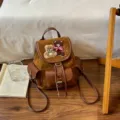 Brown faux-suede backpack with teddy bear embroidery, bow detail, flap pockets and drawstring top - 22*12*24cm / Brown