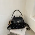 Black spotted convertible backpack with a heart clasp, top handle, and teddy bear charm - Black