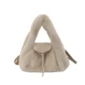 Detail view of a beige plush bag with a flap, long tassel, leather strap and metal hardware - Khaki