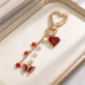 Close-up of a gold-tone heart clasp with red heart and butterfly charms, pearl beads and chains - Red Heart & Butterfly Artificial Pearl Style (ZJ17291)