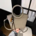 Beige woven-texture bucket bag with a round handle, adjustable shoulder strap, and bead charm - With Pendant / Gray