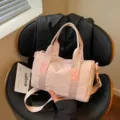 Roze cilindervormige sporttas met handgrepen, ritssluiting en afneembare schouderriem - Roze