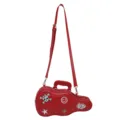 Red guitar-shaped crossbody bag with adjustable strap, top handle, zipper, and playful patches - Red