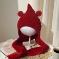 Close-up of a red cable-knit winter hat with pointed crown, twin pom-poms and long ties - Baby 2-5 Years Old Elastic / Burgundy