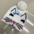 White knitted children's beanie with a cat face, blue bow, pink nose and fluffy pom-pom - One Size (3-8 Years) / Cat White