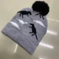 Gray children's knit beanie with black pom-pom, folded cuff and black-and-white dinosaur pattern - One Size (3-8 Years) / Dino Gray