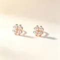 Paire de clous en forme de trèfle, dorés rose et ornés de pierres claires, sur fond ivoire doux - Argent 990 / Or rose