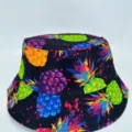 Front view of a black bucket hat with vivid pineapple and berry prints on a clean white background - M (56-58cm) / Black Base Pineapple Print Style (34)