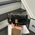 Bolso bandolera negro acolchado de cuero sintético, con cadena dorada y cierre metálico brillante - Negro