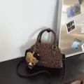 Brown leopard-print Boston bag with dark handles, shoulder strap, gold hardware and cat charm - With Pendant / Leopard Coffee