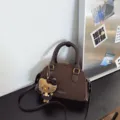 Brown suede and faux leather Boston bag with top handles, crossbody strap, and plush charm - With Pendant / Coffee