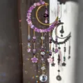 Close-up of purple crystal beads, enamel flowers and hanging faceted prisms on a gold crescent - Amethyst Moon Hanging Style (26054)