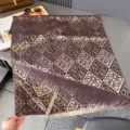 Flach ausgelegter brauner Jacquardschal mit wiederholtem Schleifenmuster und hellen Fransen - 185x65cm / Kaffeebraun