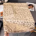 Vista ravvicinata di una sciarpa beige con cuori e motivi leopardati, rifinita con frange - 185x65cm / Kaki