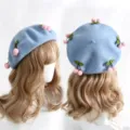Light blue wool beret with pink cherry pom-poms and green leaf details, shown from two angles - M (56-58cm) / Pink Cherry Milk Blue Hat