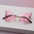 Détail de lunettes papillon sans monture, avec verres roses et bordure de perles multicolores - Rose Lotus