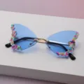 Vue détaillée de verres bleus dégradés en forme papillon, ornés de détails colorés et d'un pont métallique fin - Bleu