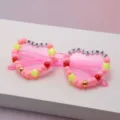 Close-up of pink heart-shaped sunglasses with colorful beads and “MERRY CHRISTMAS” letter charms - Pink