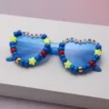 Close-up of blue sunglasses with beaded frames spelling “Merry Christmas” and star accents - Dark Blue
