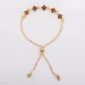 Gold-tone bracelet displayed flat, with five brown crystal flower motifs and adjustable slider clasp - Coffee (5330)