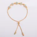 Flat-lay view of a gold-tone chain with multicolor four-petal rhinestone flowers and sliding clasp - Four Leaf Flower Bracelet (5332) / AB Multi-Color