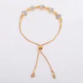 Detail of a gold-tone bracelet with five four-petal crystal flowers and an adjustable slider clasp - Four Leaf Flower Bracelet (5333) / White
