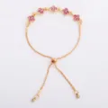 Flat lay showing five pink flower-shaped stones, gold-tone chain, and sliding bead clasp - Four Leaf Flower Bracelet (5334) / Pink