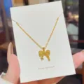 Close-up of a gold bow pendant on a fine chain, displayed on a white jewelry card - Bowknot Pendant Style (X507) / 1-Piece Pack / Gold